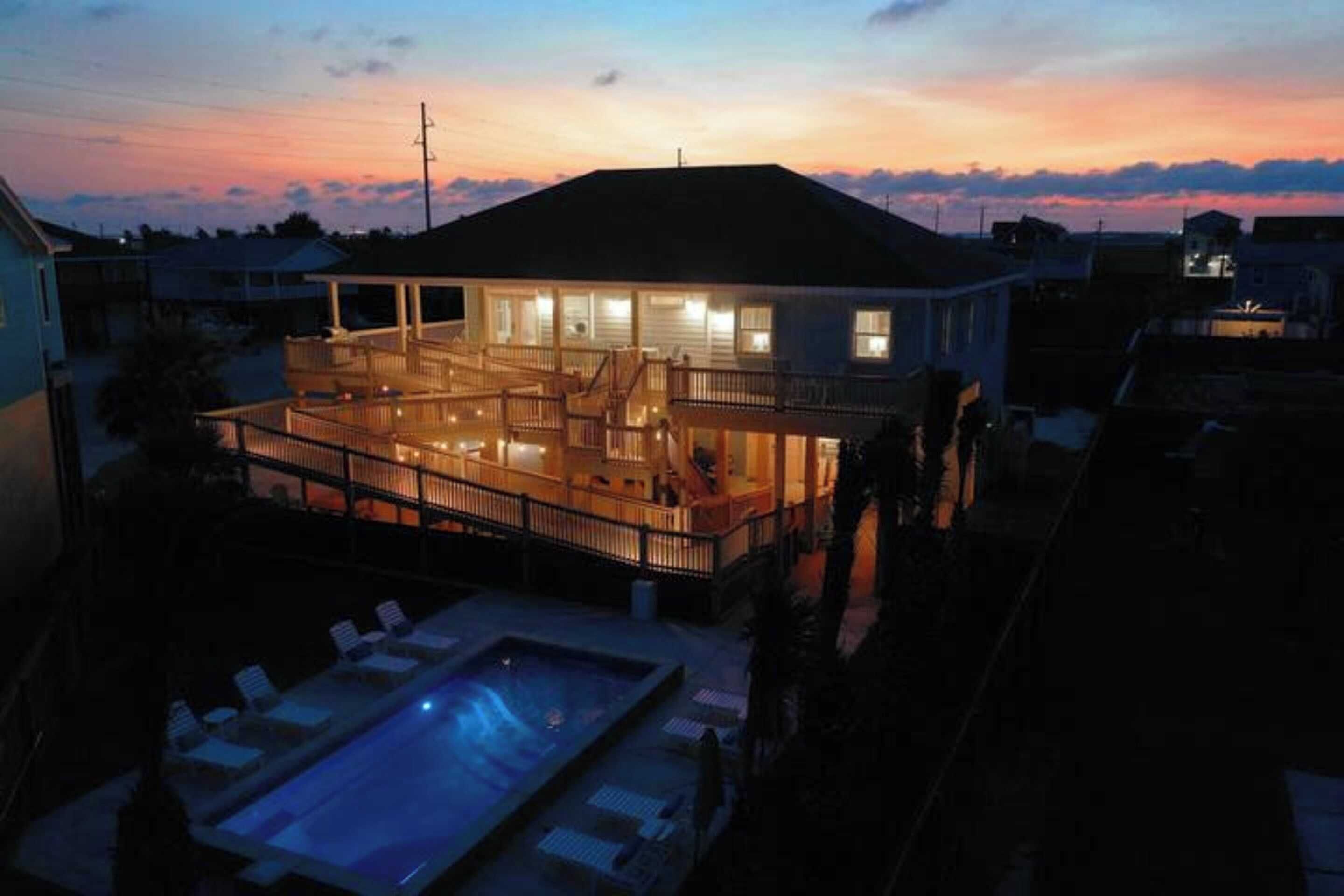 A two-story house with a balcony and a swimming pool.
