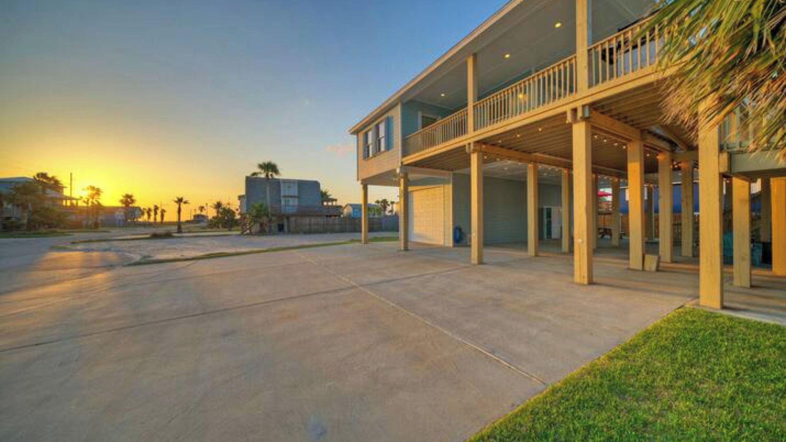 A two-story building with a covered outdoor area, a garage, and a clear sky.