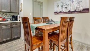 A dining area with a wooden table and chairs, a green tablecloth, and a kitchen in the background. - Rural Retreat w/ Covered Porch Near Jackson (Grove Hill)