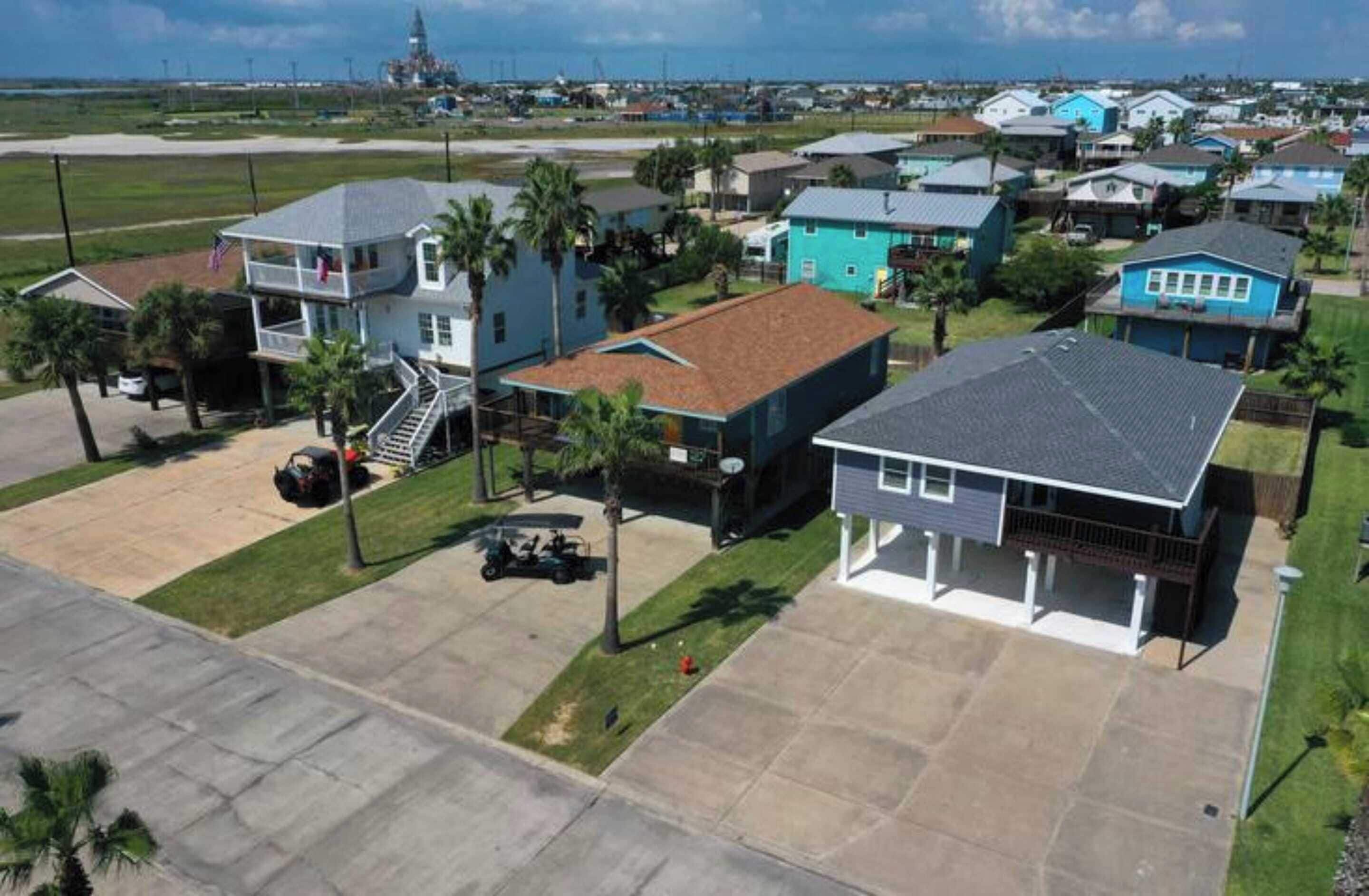 Zona residencial amb cases, un parc infantil i una vista despejada de l'oceà.