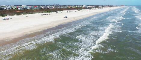 A beach with a row of buildings along the shore.