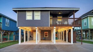 Een huis met twee verdiepingen, een overdekte patio, een balkon en een bordje dat aangeeft dat huisdieren welkom zijn.