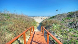 A wooden pathway leading to a beach with a clear sky. - Ocean View w/ Pool, Tennis/pickleball, Beach Access Summer Love by Avantstay (Port Aransas)