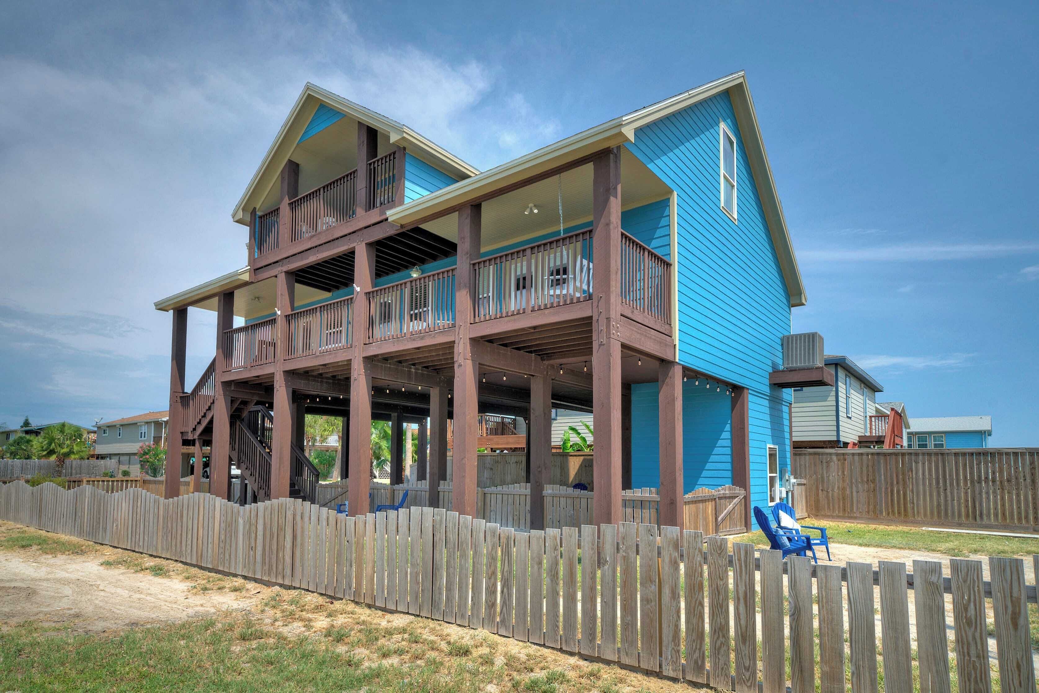 A two-story house with a wooden deck and a blue exterior.