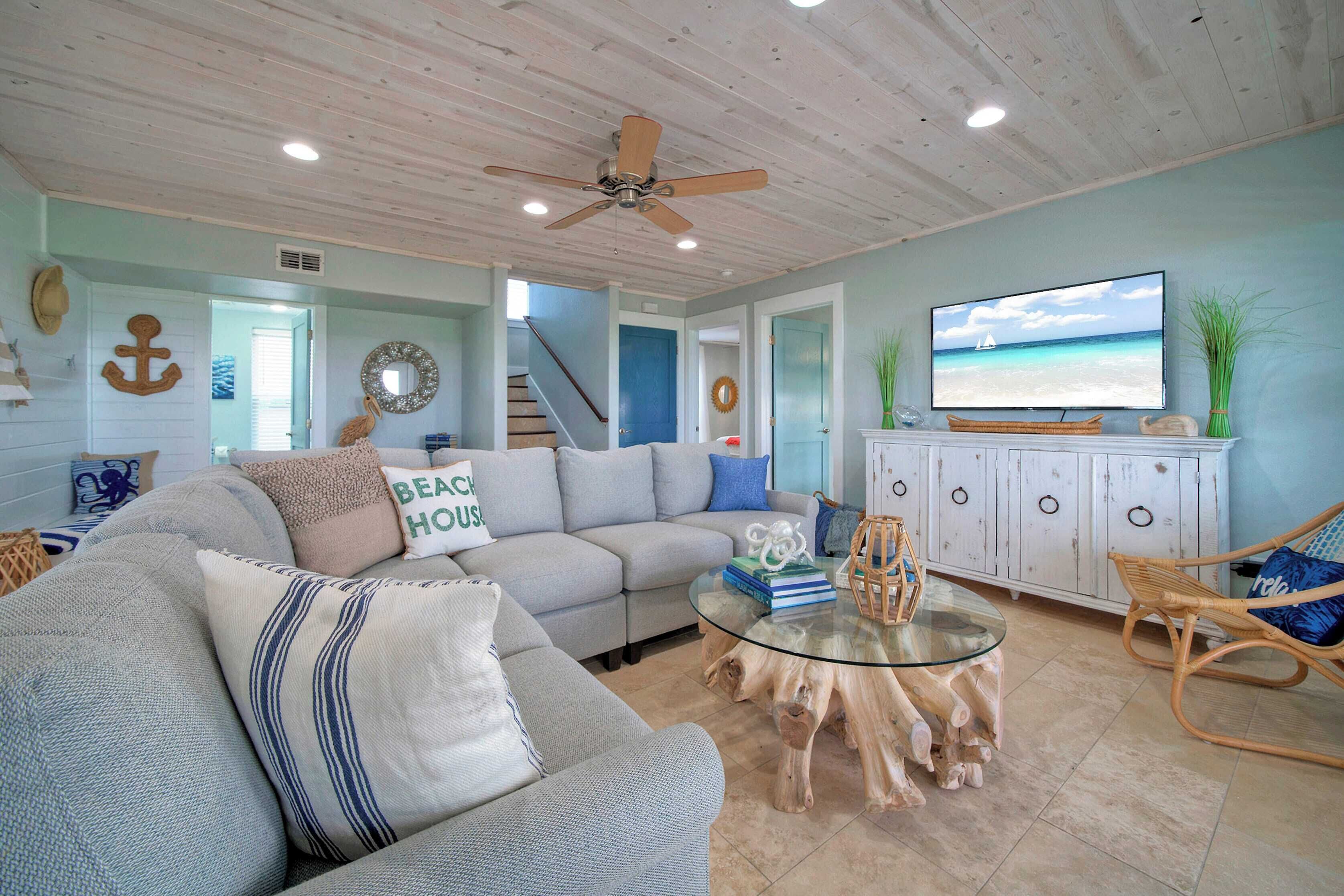 A living room with a sofa, a glass coffee table, and a television.