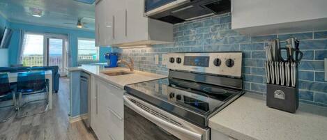 A modern kitchen with a built-in oven, a microwave, and a knife block.