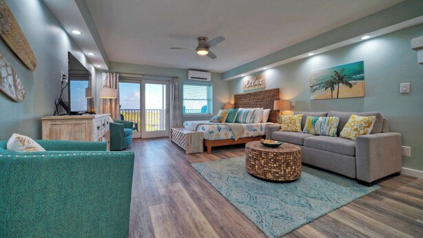 A spacious living room with a sofa, a coffee table, and a TV. - Beachfront Condo, Prvt Balcony w/ View, Pool Access Beach Happy by Avantstay (Port Aransas)