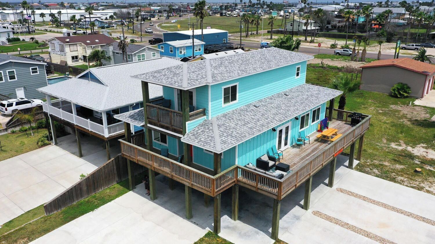 A two-story house with a balcony and a deck, surrounded by a residential area.