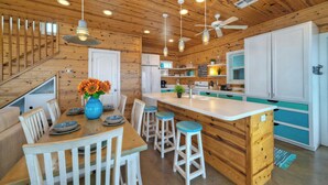 A wooden interior with a dining area, kitchen, and bar. - Gated Community w/ Pool 5mins to Beach Latitude Adjustment by Avantstay (Port Aransas)