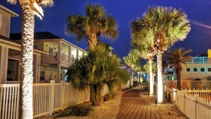 A beachfront property with a paved walkway, palm trees, and a white fence. - Gated Community w/ Pool 5mins to Beach Latitude Adjustment by Avantstay (Port Aransas)