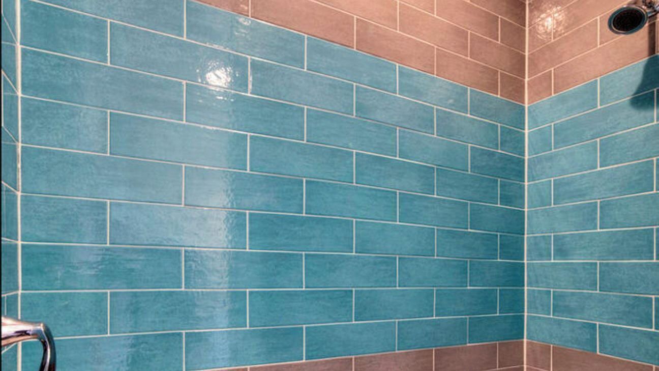 Esquina de una habitación con paredes de azulejos azules y marrones.