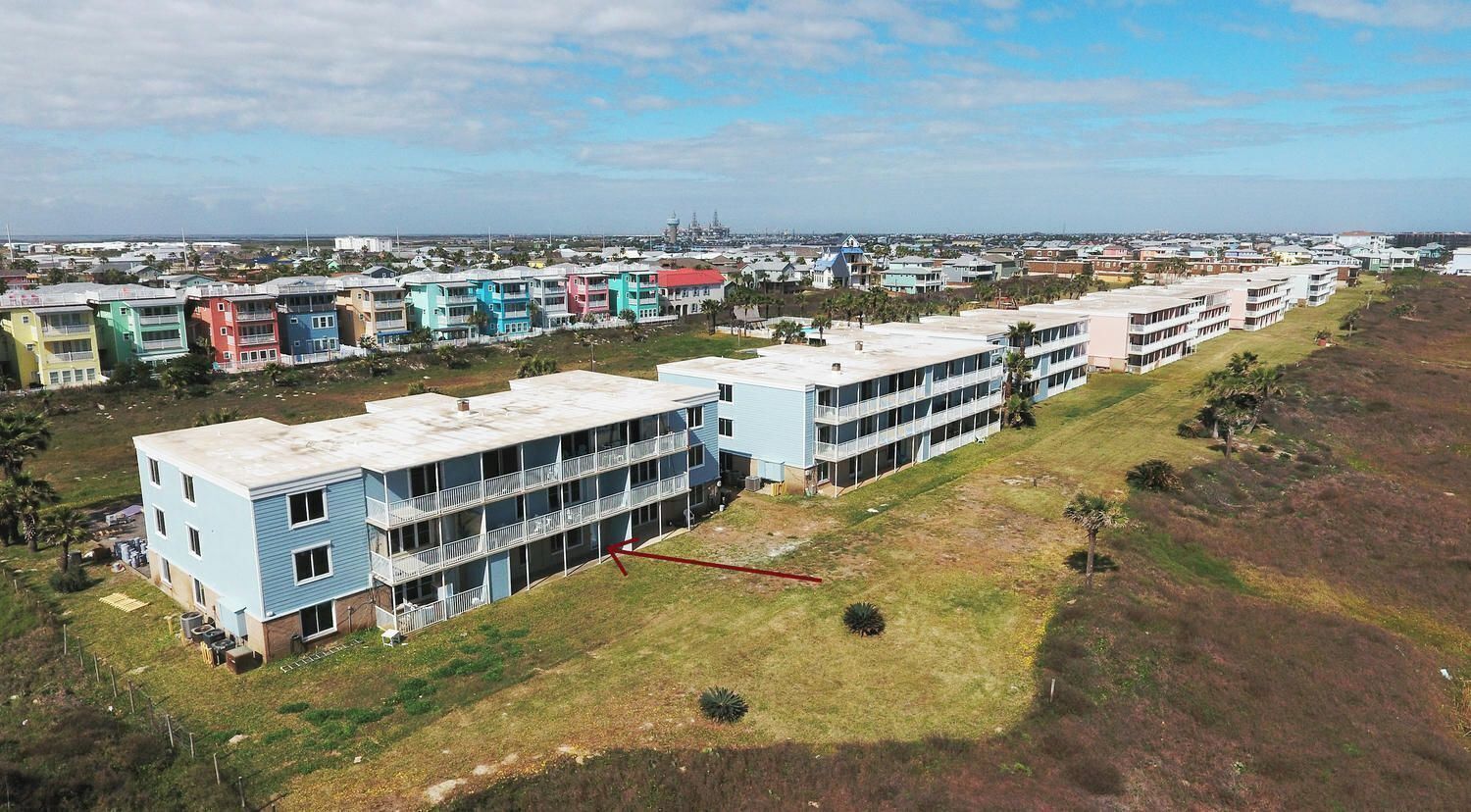 Zona residencial con edificios de varios pisos, algunos con balcones, y una vista despejada del paisaje circundante.