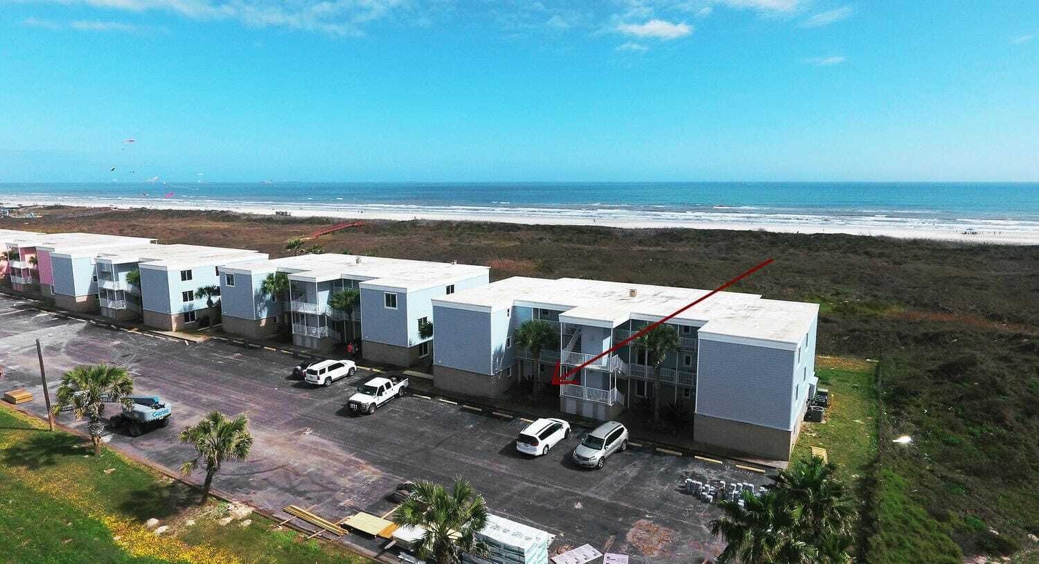 Un hôtel à plusieurs étages, doté d’un parking et offrant une vue sur la plage.