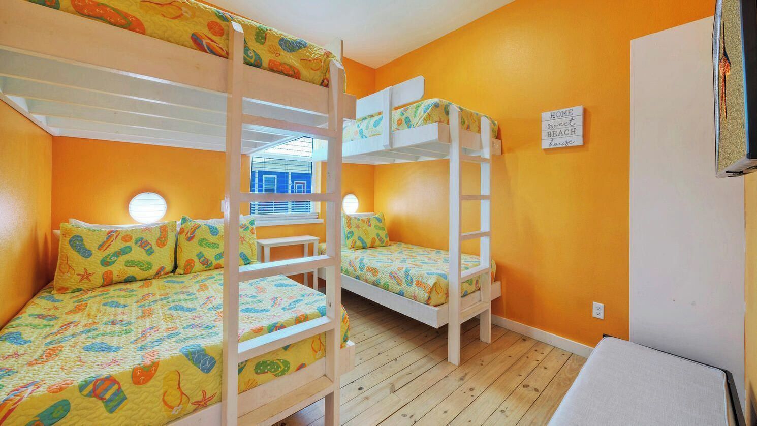 A room with bunk beds, a window, and a sign on the wall.