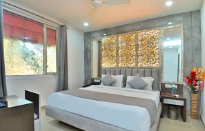 A modern bedroom with a large bed, a desk, and a vanity with a mirror. - Hotel Bella Vista New Delhi-walk from New delhi railway station (New Delhi)