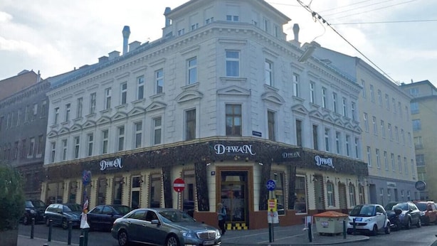 Een meerlaags gebouw met een klassieke architectuur, met een opvallend 'DeWACN' bord op begane grond.