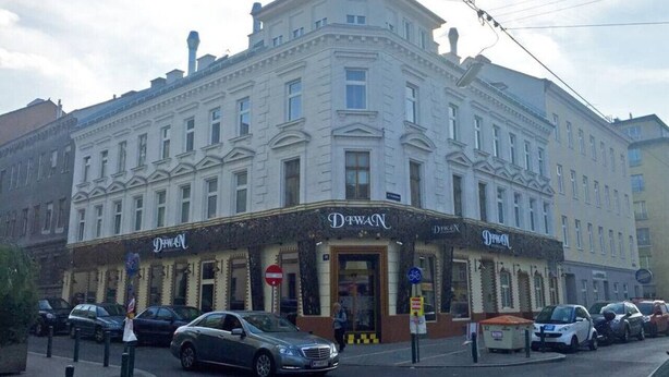 Un immeuble à plusieurs étages, de style architectural classique, dont l’entrée est marquée par une enseigne bien visible portant le nom « Dewan ».