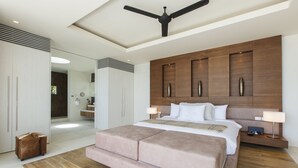 A modern bedroom with a large bed, a ceiling fan, and a wooden headboard. - Zest 4 Bed : Ultra-Luxurious Five Star Villa (Koh Samui)