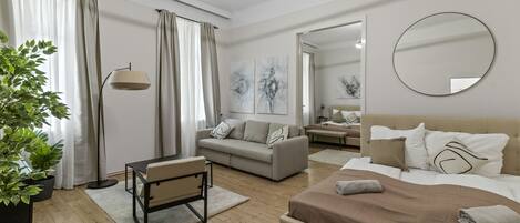 Une chambre à coucher moderne et bien éclairée, avec un grand lit, un canapé et un bureau.