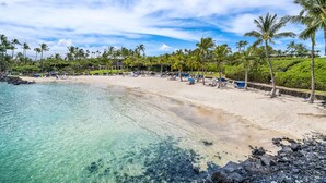 A beach with clear turquoise water, a sandy shore, and palm trees. - Golf Course Front - Upgraded - Kulalani Mauna Lani (Waimea)