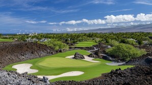 A golf course with bunkers, a water hazard, and a mountainous backdrop. - Golf Course Front - Upgraded - Kulalani Mauna Lani (Waimea)