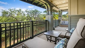 A covered outdoor seating area with a view of trees and a fence. - Golf Course Front - Upgraded - Kulalani Mauna Lani (Waimea)
