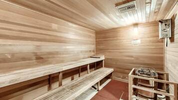 A sauna room with wooden benches and a metal rack for towels.
