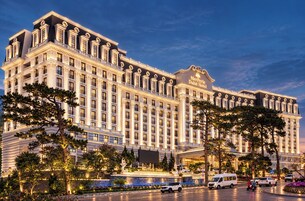 Un hotel grande de varios pisos con un estilo arquitectónico clásico, que cuenta con una entrada destacada y una fachada bien iluminada.