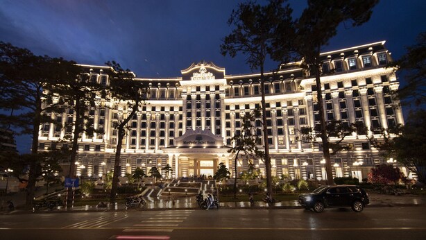 A large, multi-story hotel with a grand entrance and a fountain in front.