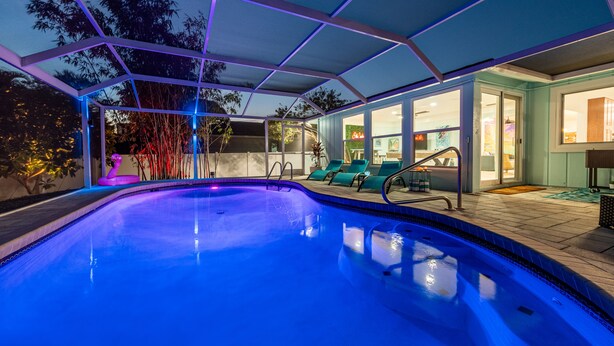 Une piscine intérieure dotée d’une paroi vitrée, entourée de chaises longues et offrant une vue sur l’extérieur.