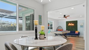 Un espace repas moderne avec une table ronde, des chaises et des objets décoratifs.
