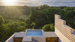 Piscina no terraço com vista para uma paisagem arborizada.