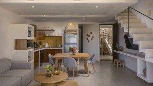 Een moderne keuken met een eethoek, een trap en een woonkamer.