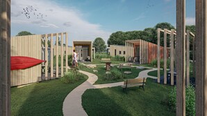 Une cour intérieure agrémentée de structures en bois, un sentier sinueux et un banc.