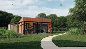 A modern house with a wooden exterior, large windows, and a paved pathway leading to the entrance. - Lodge in Arcen by Recreational Lake (Arcen)