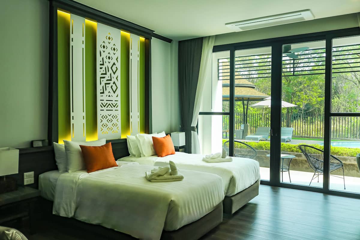 Une chambre d’hôtel avec deux lits, une grande fenêtre donnant sur l’extérieur et un aménagement intérieur moderne.