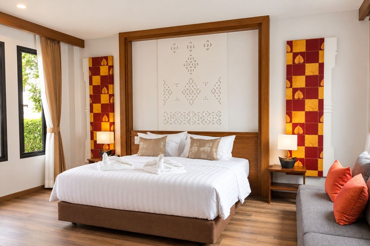 A hotel room with a large bed, a wooden headboard, a sofa, and a decorative wall panel.