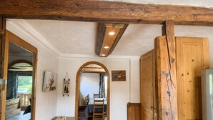 A wooden interior with a table, chairs, and a view into another room. - Apartment "Les Dolomites" with Mountain View, Private Terrace and Wi-Fi (La Plagne-Tarentaise)