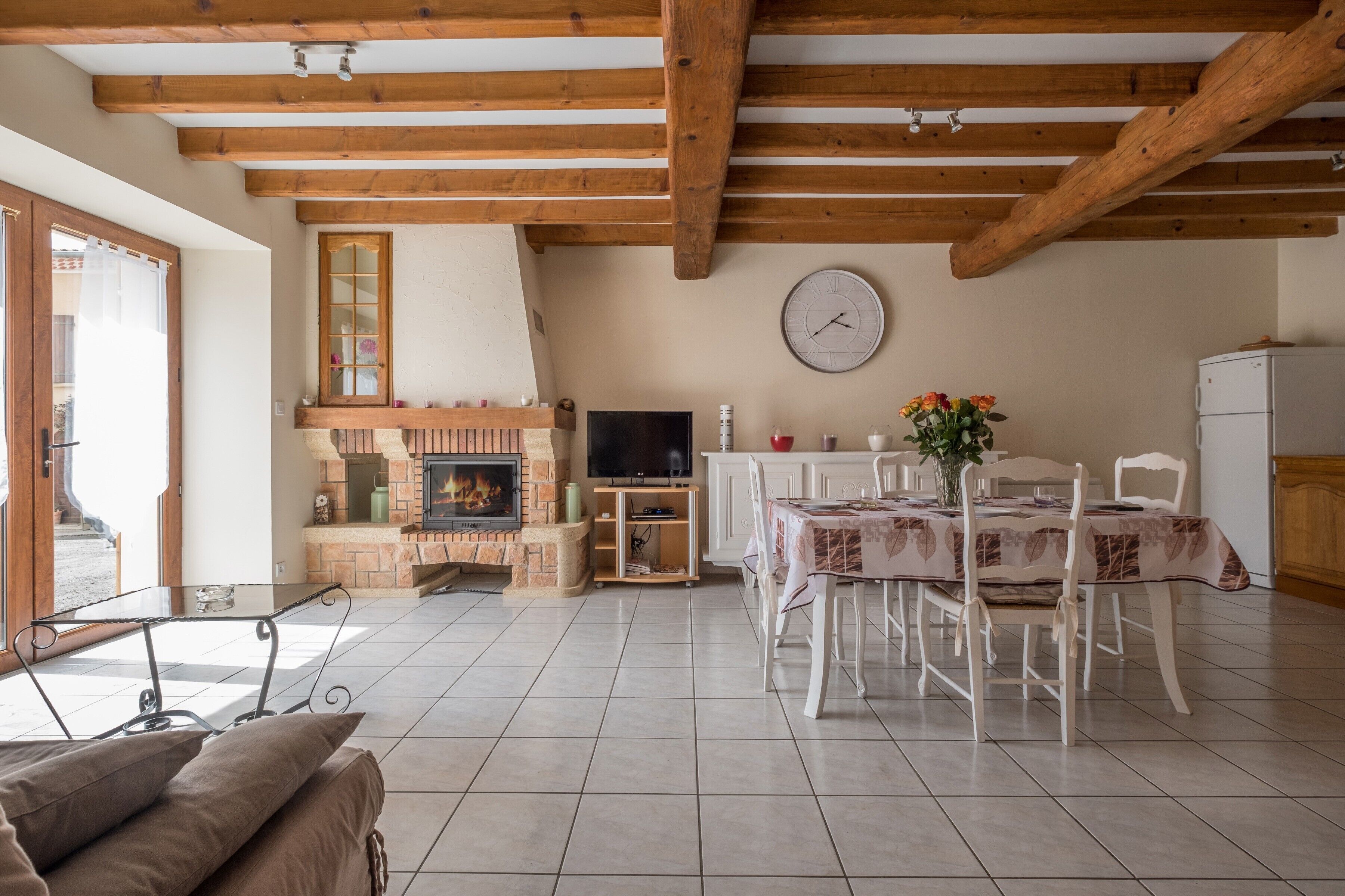 A living room with a fireplace, a dining table, and a TV.