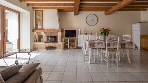 Una sala de estar con chimenea, una mesa de comedor y un televisor.
