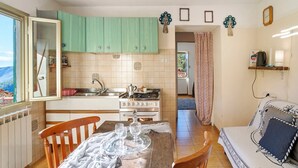 Una cocina compacta con mesa, sillas y sofá.