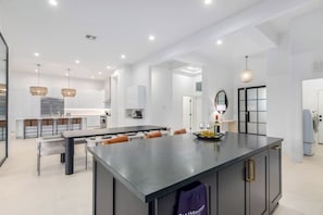 A modern kitchen with a central island, pendant lighting, and a large mirror. - Anderson LUX Estate/Private Bar&Pool/Sleeps 12 (Scottsdale)