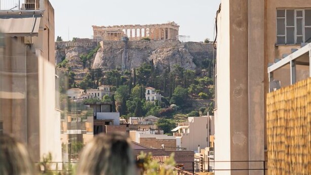 A rooftop pool with a view of a historic building. - Okupa (Athens)