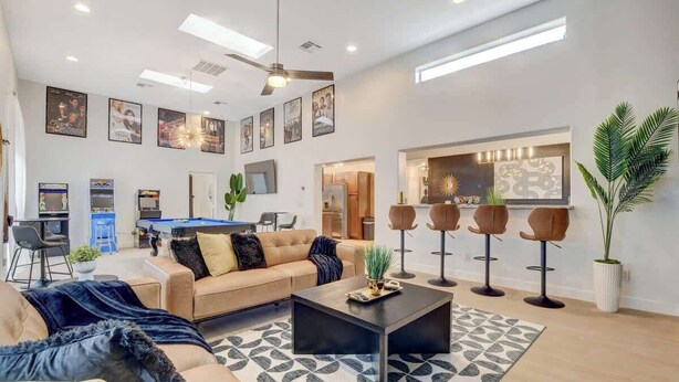 Una sala de estar moderna con sofá, mesa de centro y zona de bar con taburetes.