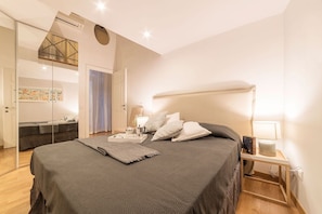 Un dormitorio moderno con una cama grande, mesitas de noche y un armario.