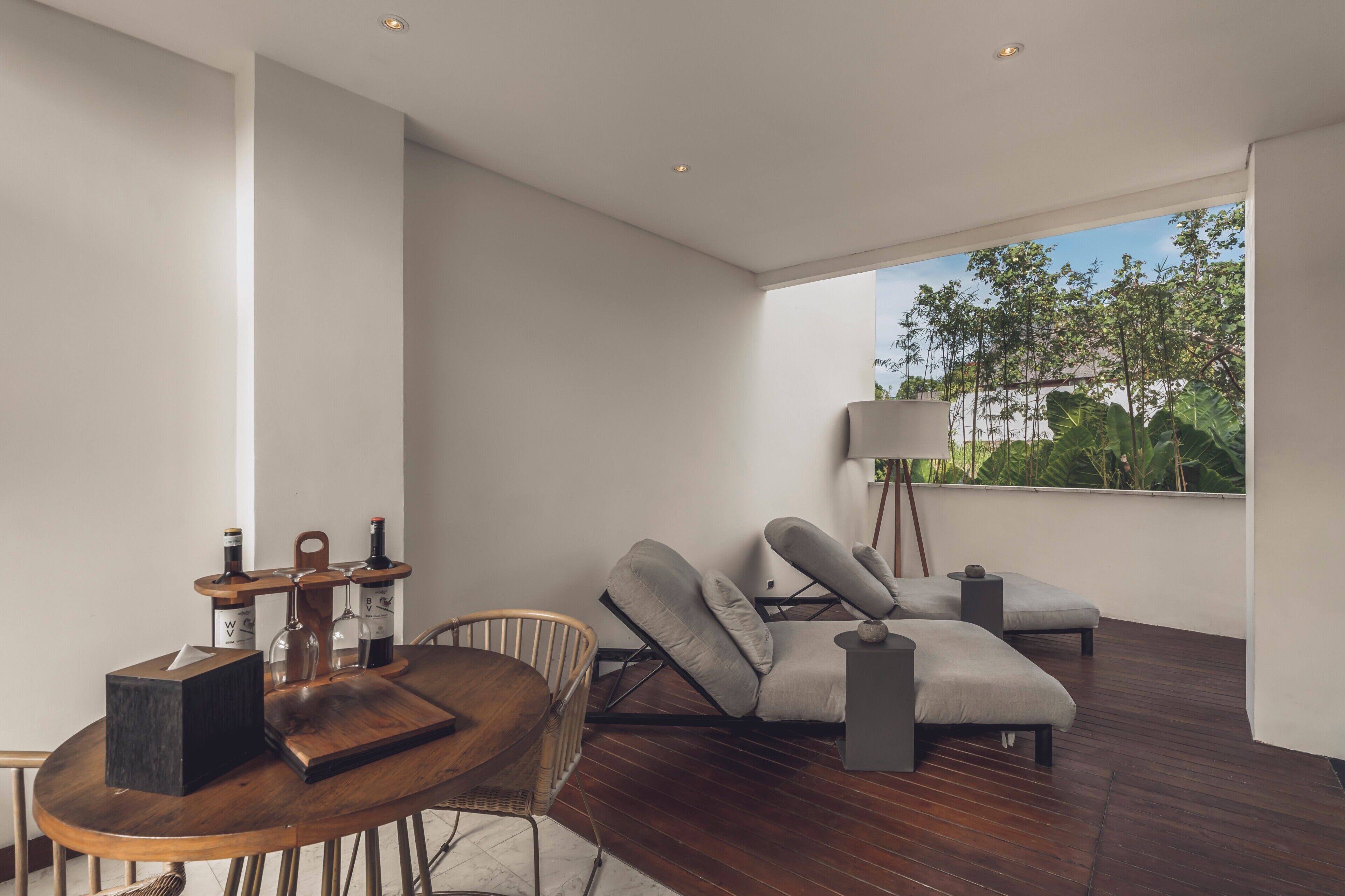 A modern interior with a dining area, seating, and a view of greenery.