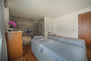 Two single beds with matching bedspreads, a wardrobe, and a large mirror.