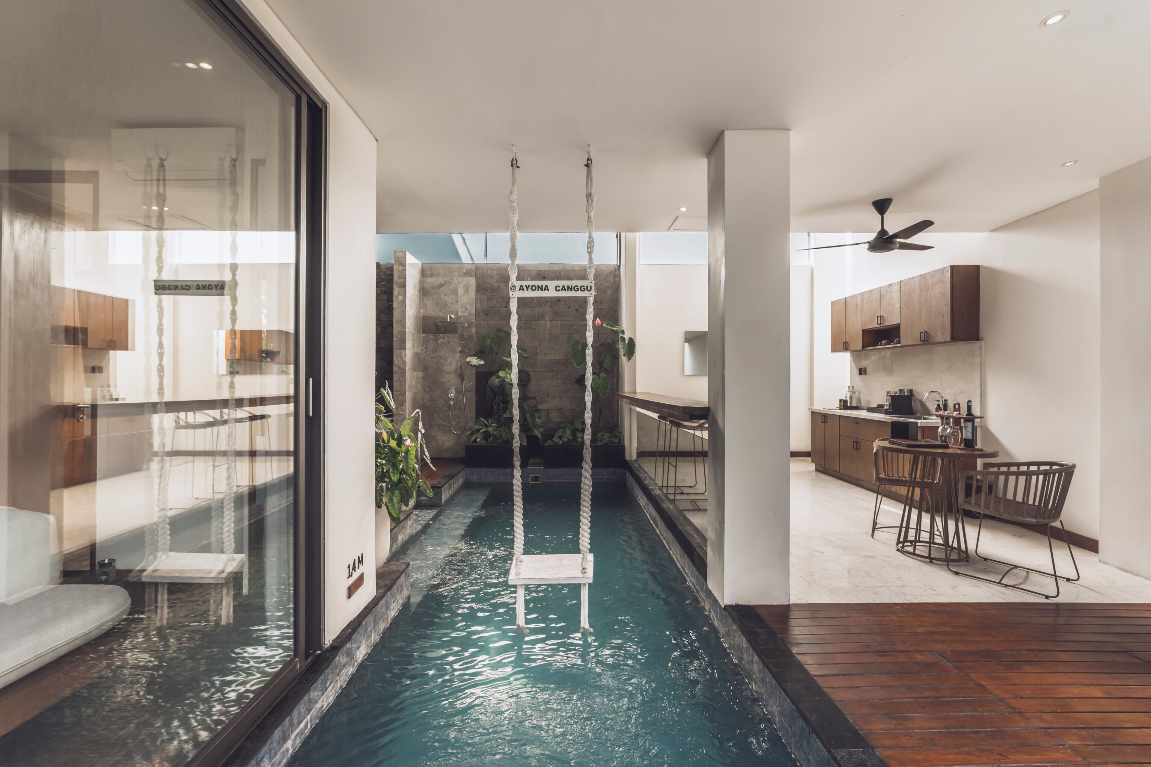 Ein modernes Interieur mit einem zentralen Wasserspiel, einer Küchenzeile und einem Essbereich.