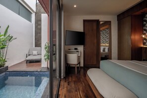 A modern interior with a pool, a sofa, a TV, and a wooden cabinet. - Ayona Villa Canggu by Ini Vie Hospitality (Canggu)