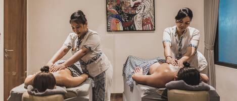 Un cuarto de terapia de masajes con dos clientes recibiendo masajes.
